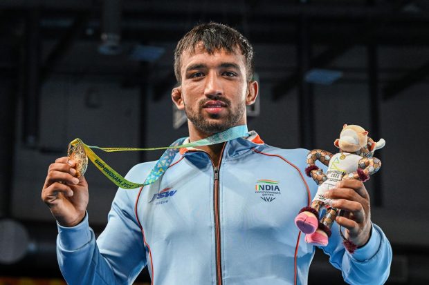 Gold medallist Naveen Kumar poses at the podium during the Men's Freestyle Wrestling 74kg event medal ceremony at the Commonwealth Games (CWG), in Birmingham, UK. (PTI Photo)