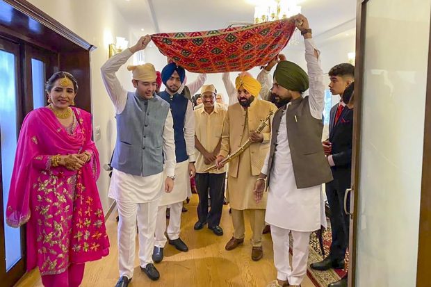 Punjab CM Bhagwant can be seen walking under a 'phulkari dupatta' held up by Chadha among others, and at the ceremony. Delhi CM Arvind Kejriwal is also seen. (PTI Photo)