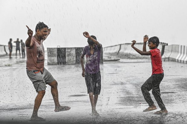 Boys play on a road amid monsoon rains, in New Delhi. Delhi region is witnessing heavy rain with the onset of monsoon, bringing much-needed relief after days of a hot and humid weather. (PTI Photo)