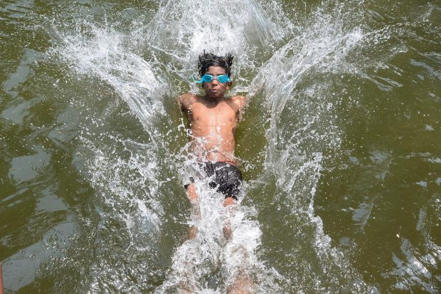 A young boy swims in the water of a canal to beat the heat on a hot summer afternoon. (PTI Photo)