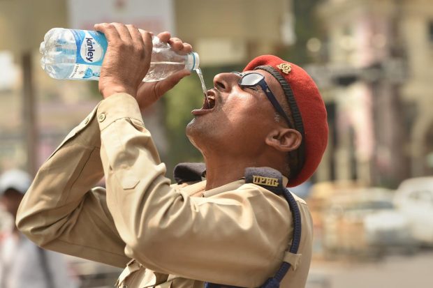 A man drinks water to quench his thirst on a hot summer day, at Hazratganj crossing in Lucknow. (PTI Photo)