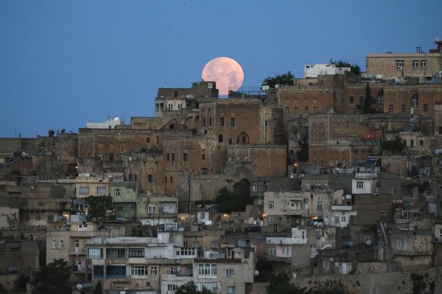 A full moon rises above the historical city center of Mardin, famous with its stone houses, in southeastern Turkey. (AP Photo)