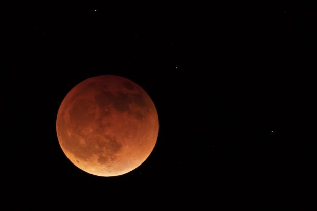 The moon is shown during a full lunar eclipse near Moscow, Idaho. The orange color of the moon is caused by the Moon passing into the shadow of the Earth. (AP Photo)