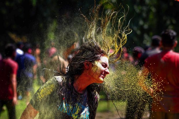 Students play with colours, a day before the festival of 'Holi' at Guru Nanak Dev University, in Amritsar. (PTI Photo)