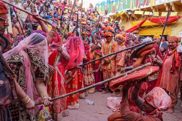 Women from Barsana beat men from Nandgaon, with sticks during 'Lathmaar Holi' celebrations, in Barsana near Mathura. (PTI Photo)