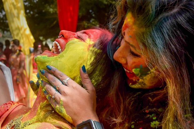 Women play with colours during celebrations of the upcoming 'Basant Utsav', at Maidan in Kolkata. (PTI Photo)