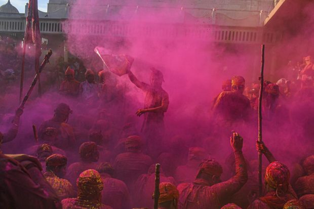 People celebrate Holi at Nandgaon, in Mathura. (PTI Photo)