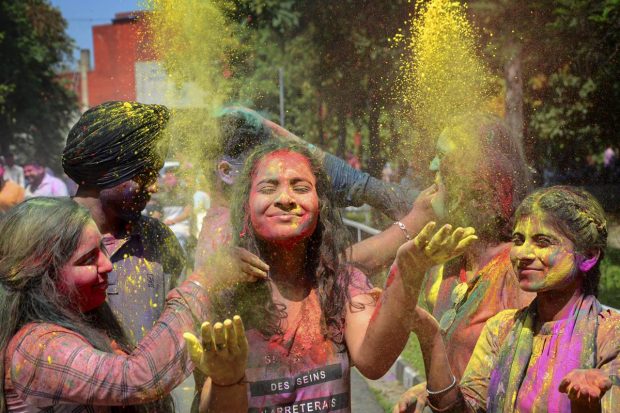 Students smear colour on each other's faces, in celebration of the festival of 'Holi' at Guru Nanak Dev University, in Amritsar. (PTI Photo)