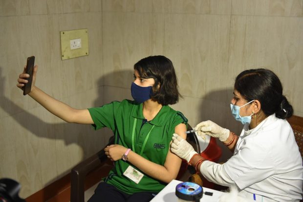 A student of the age group 12-14 years, clicks a selfie while getting administered a dose of the Covid-19 preventive vaccine at the Civil Hospital, in Lucknow. (PTI Photo)