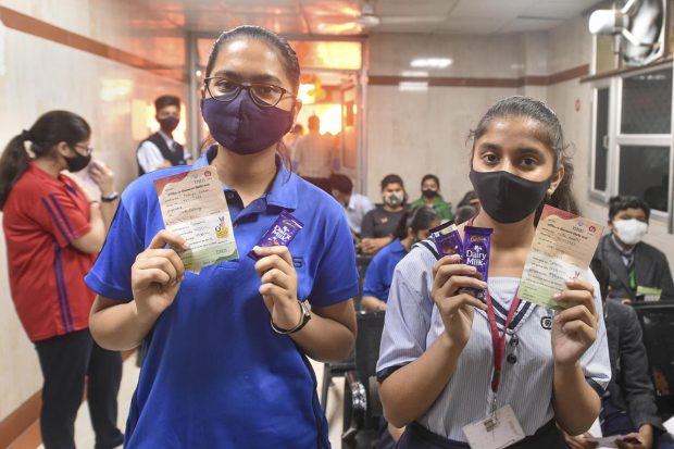 Students in the age group of 12-14 years, show their vaccination certificates after getting administered a dose of the Covid-19 preventive vaccine at the Civil Hospital in Lucknow. (PTI Photo)