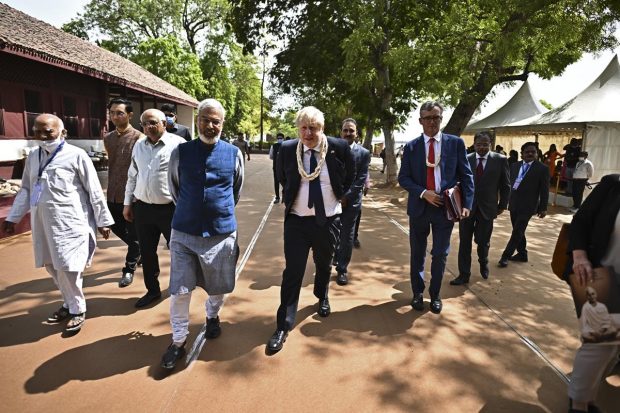 Boris Johnson walks along with Kartikeya Sarabhai and the chief minister of Gujarat Bhupendra Patel during his visit at the Sabarmati Ashram in Ahmedabad. (AP Photo)