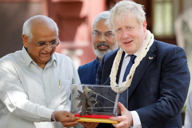 Britain's Prime Minister Boris Johnson receives a memento from Bhupendra Patel, Chief Minister of Gujarat, during his visit to Gandhi Ashram in Ahmedabad. (Reuters Photo)