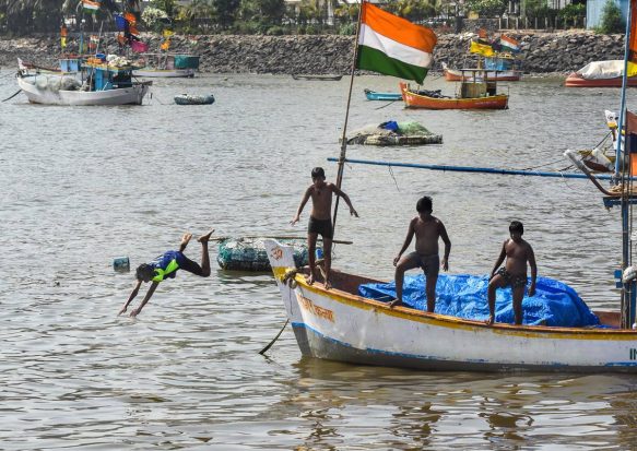 Boys jump into the Arabian Sea to beat the heat on a hot summer day, at Badhwar Park in Mumbai. (PTI Photo)