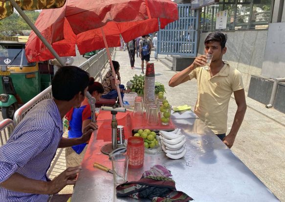 A man quenches his thirst at a roadside vendor outside a metro station in New Delhi. (AP Photo)