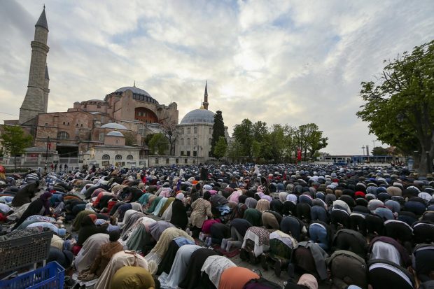 Muslims offer prayers during the first day of Eid al-Fitr, which marks the end of the holy month of Ramadan outside the iconic-historic Haghia Sophia Mosque in Istanbul, Turkey. (AP Photo)