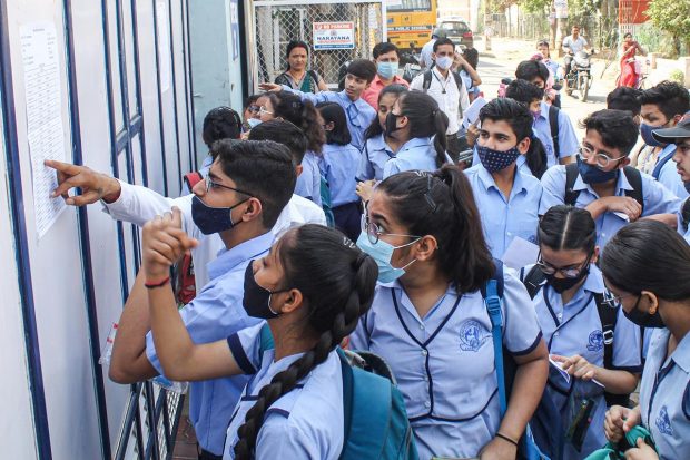 Gurugram: Students check the notice board for their allotted seats before appearing for the CBSE 10th class exam for Term 2, outside an examination centre, in Gurugram. (PTI Photo)