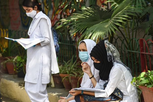 New Delhi: Students revise for the exam before appearing for the CBSE Exam for Term 2, outside an examination centre, in New Delhi. (PTI Photo)