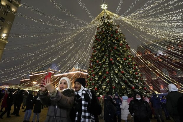 People celebrate the New Year the Christmas tree in Manezhnaya Square near an empty Red Square due to pandemic restrictions during to New Year's celebrations, in Moscow, Russia. (AP/PTI Photo)