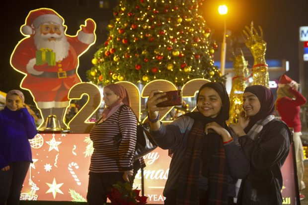 People pose with Christmas tree and 2022 form as they celebrate the new year in Cairo, Egypt. (AP/PTI Photo)