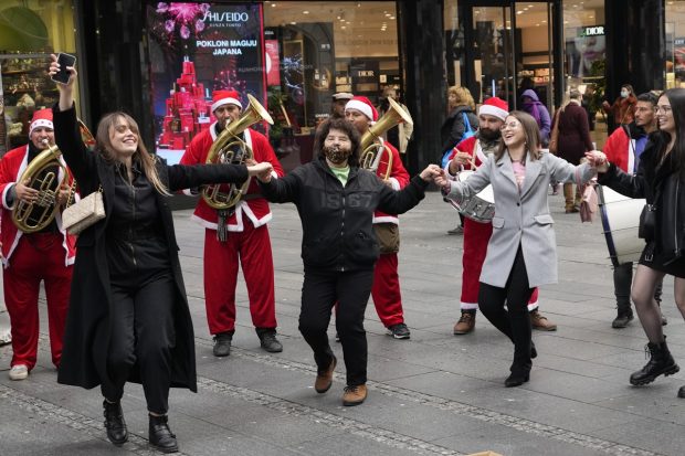 Women dance on the Belgrade's main pedestrian street in front of brass band prior a New Year's Eve, Serbia (AP Photo)