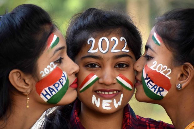 Youngsters with their face painted pose for photographs on New Year's eve, in Prayagraj (PTI Photo)