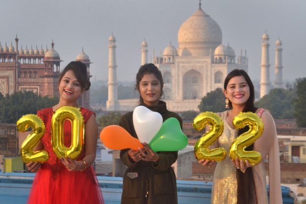 Women pose for photographs in front of the historic Taj Mahal on New Year's eve in Agra (PTI Photo)